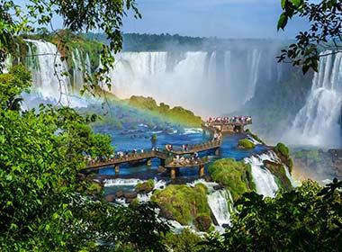 looking down to the bridge at iguazu falls brazil surrounded by jungle and waterfalls