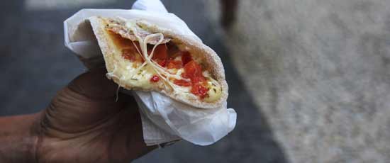 Traveller trying the local food tapioca crepe fillerd with cheese and other fillings 