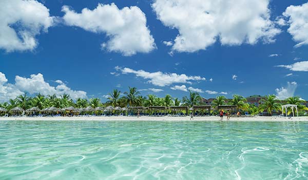 clear turqoise sea and white beach palm trees in cuba playa los cocos beach in cuba