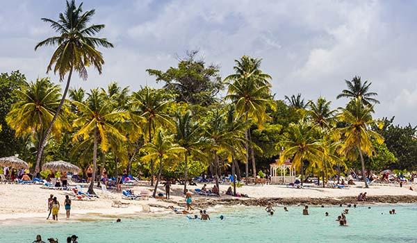 playa guardalavaca beach in cuba with palm trees and people swimming in the sea