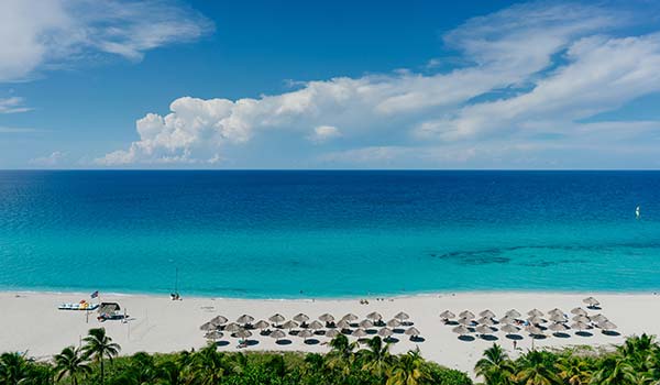 white sand beach in cuba varadero beach with umbrella sun loungers facing the sea