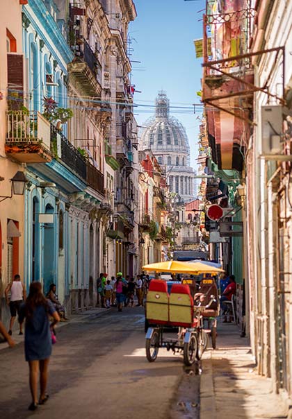 colourful buildings in streets of old havana cuba with rickshaw