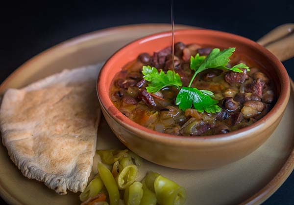 egyptian food dish of ful medames with pitta and chillies