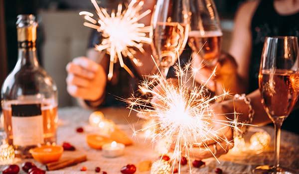 group of friends drinking wine and lighting sparklers for new years celebrations in georgia