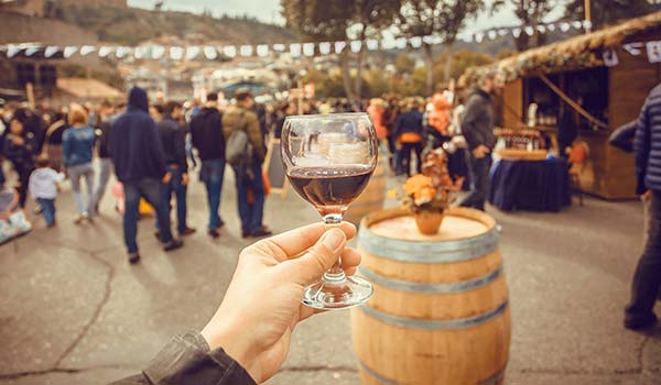 holding up a glass of georgian red wine at the new wine festival in georgia