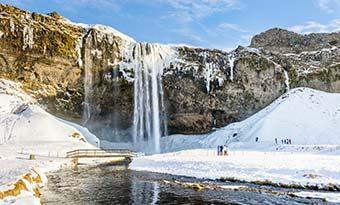 group tour to iceland in winter to see best waterfall in iceland frozen seljalandsfoss waterfall