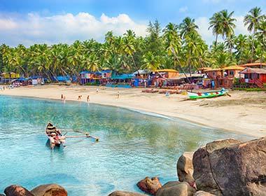 boat in the sea on bay in goa with white sand and palm trees lining the beautiful beach