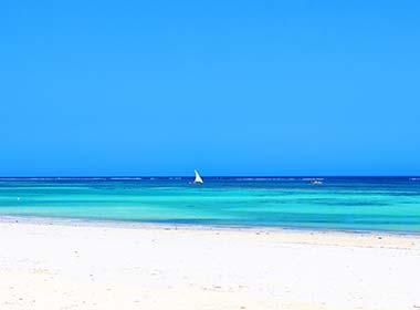 white sand beach and turqoise sea at mombasa beach on a group tour to kenya