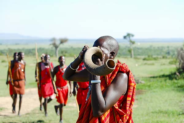 traditional african tribes wearing red blowing horn at lake turkana festival in kenya