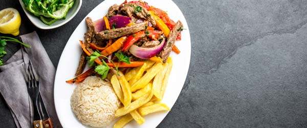 A meat dish served with onion, chili and tomato