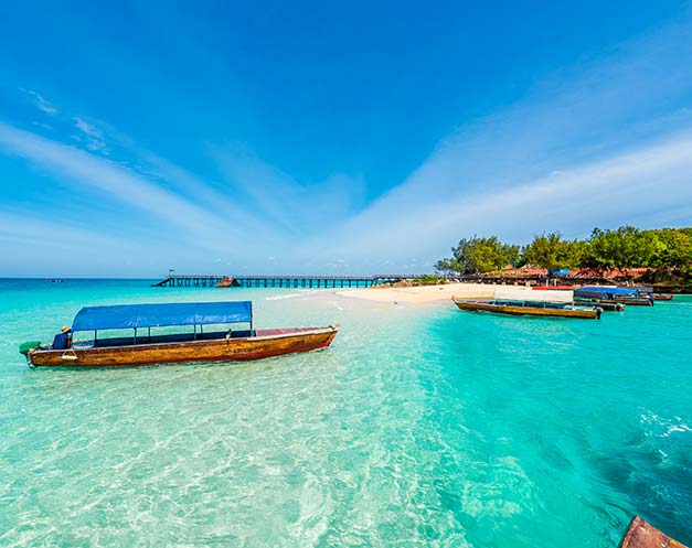 small boats lining paradise white sand beach zanzibar island tanzania