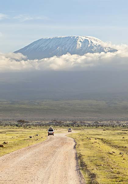 jeeps driving along the road towards mount kilimanjaro tanzania africa