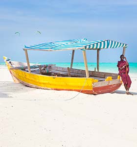 boat on the white beach of zanzibar in tanzania