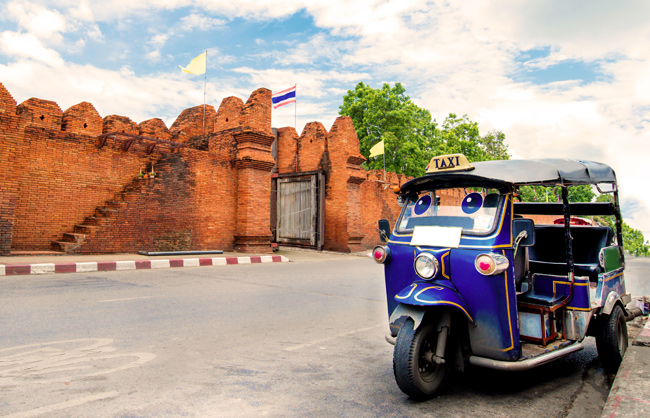 A traditional tuk tuk outside the old city walls of Chiang Mai