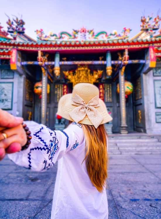 travel couple wondering through ho chi minh city visiting china town and the cultural buildings of the area