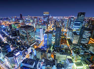 view of the city of osaka at night with skyscrapers on a tour to Japan