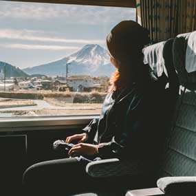 female solo tourist on the train passing mount fuji in the distance