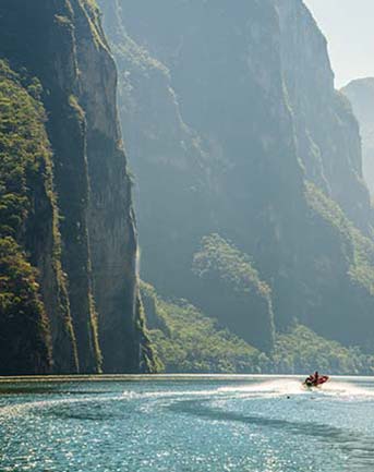 riding a jet ski on paradise beach in Mexico with cliffs and jungles along the shore