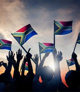 A group wave the South African flag at an event