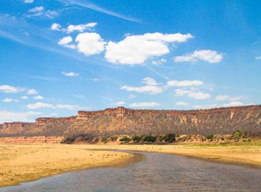 river running through gonarezhou national park with red sand stone cliffs